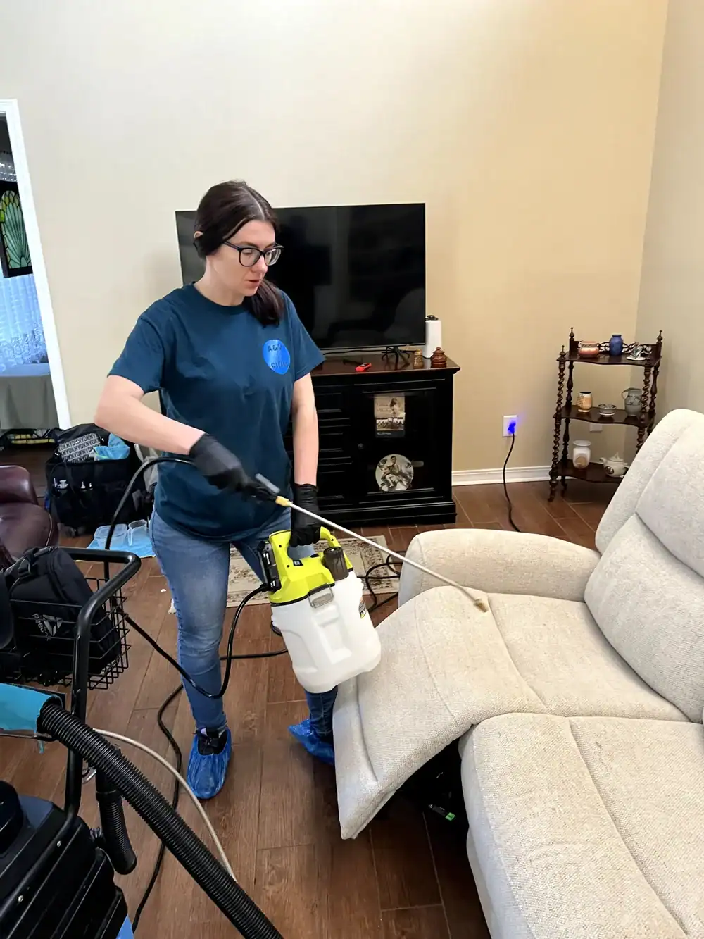 Technician applying pre-spray solution to upholstered furniture during cleaning in Jacksonville, FL